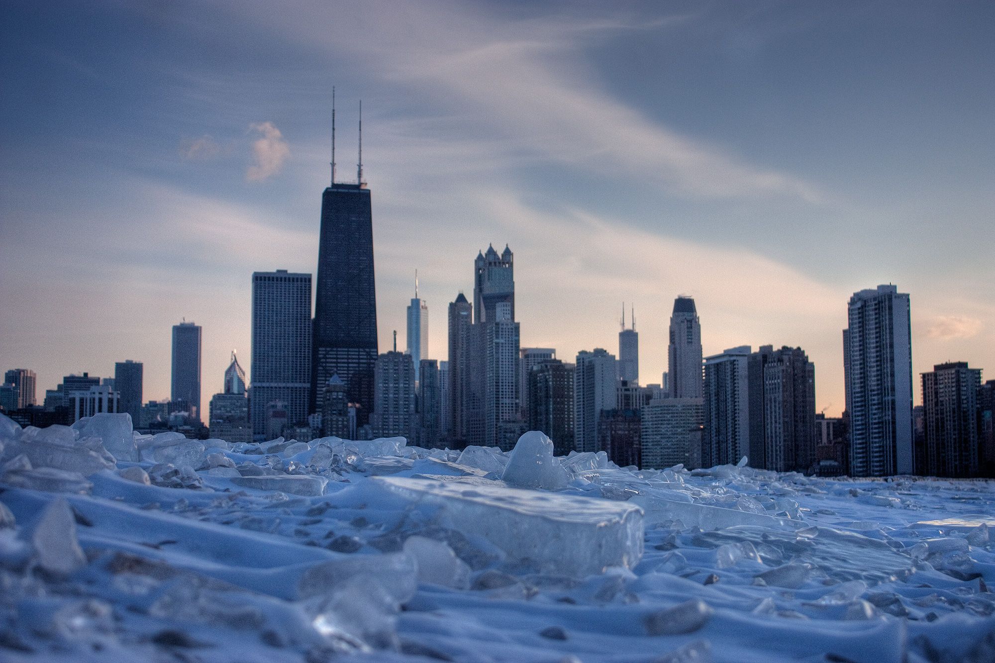 a frozen chicago skyline with ice in the foreground.