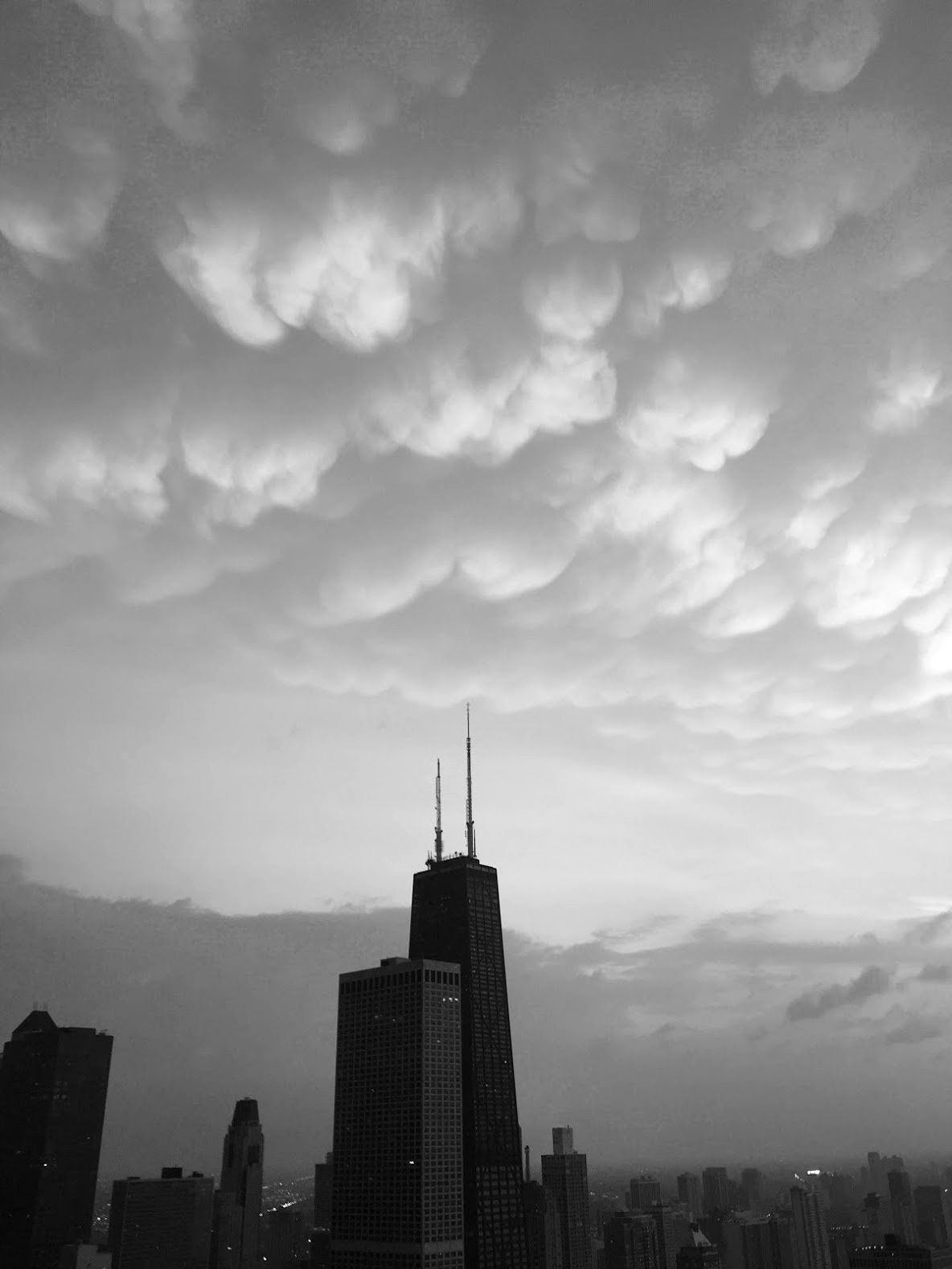 black and white photos of chicago skyline with some looming mammatus clouds.