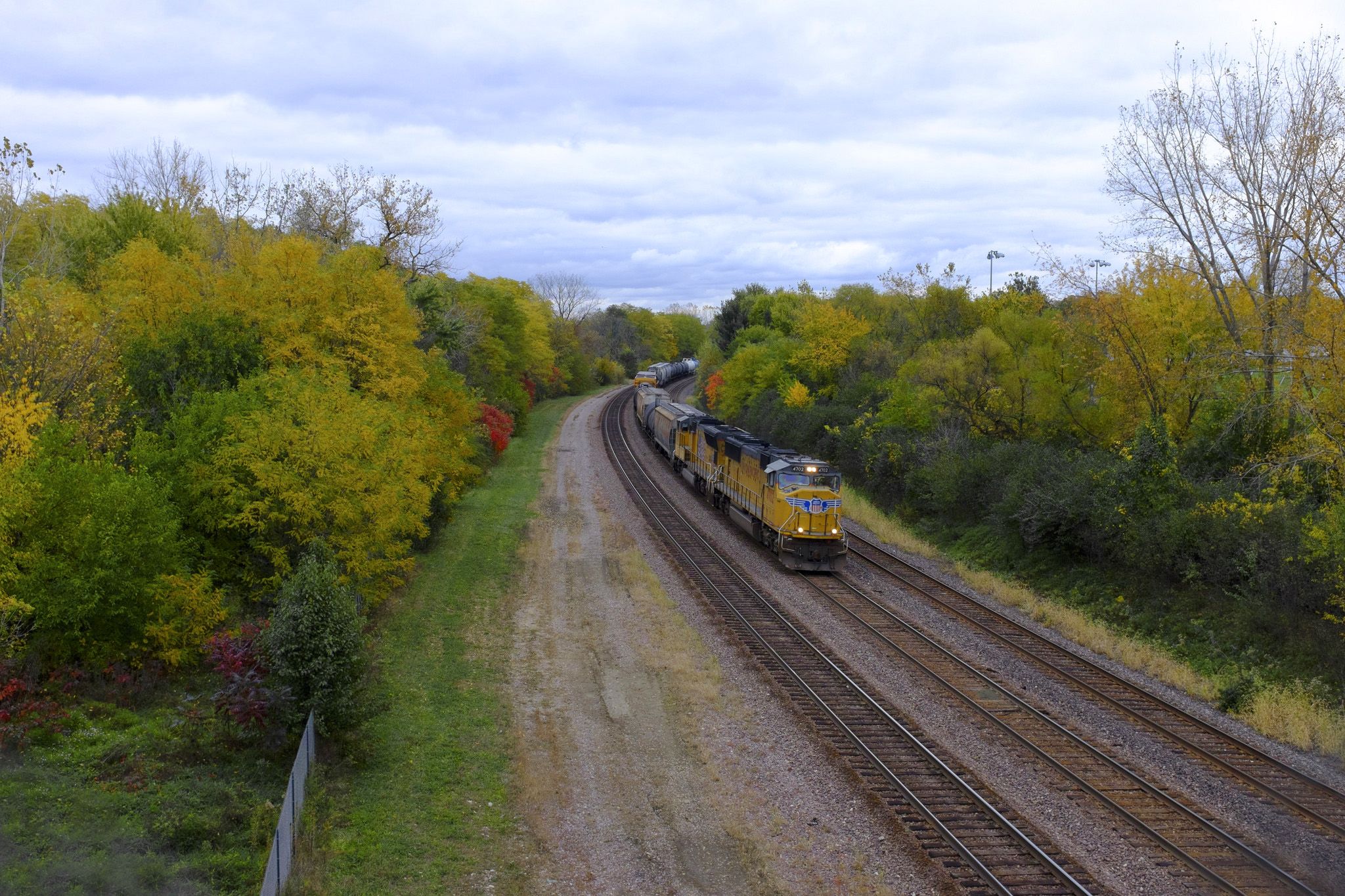 a westbound union pacific freight train surrounded by Fall foilage
